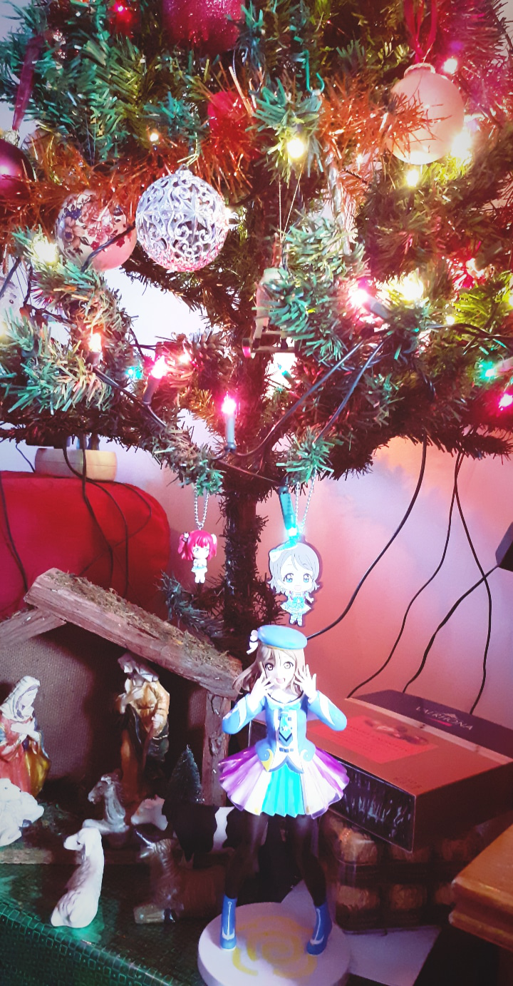 Here's a part of my Love Live merch in front of my Christmas tree! Merry Christmas to all!!!^ ^